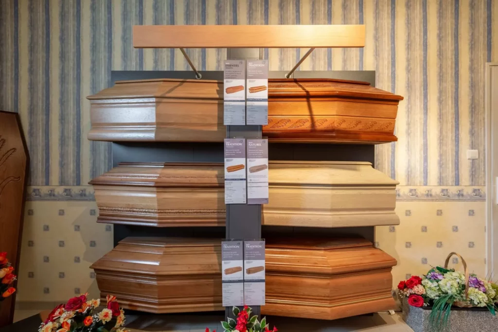 Exposition de modèles de cercueils en bois dans un salon funéraire