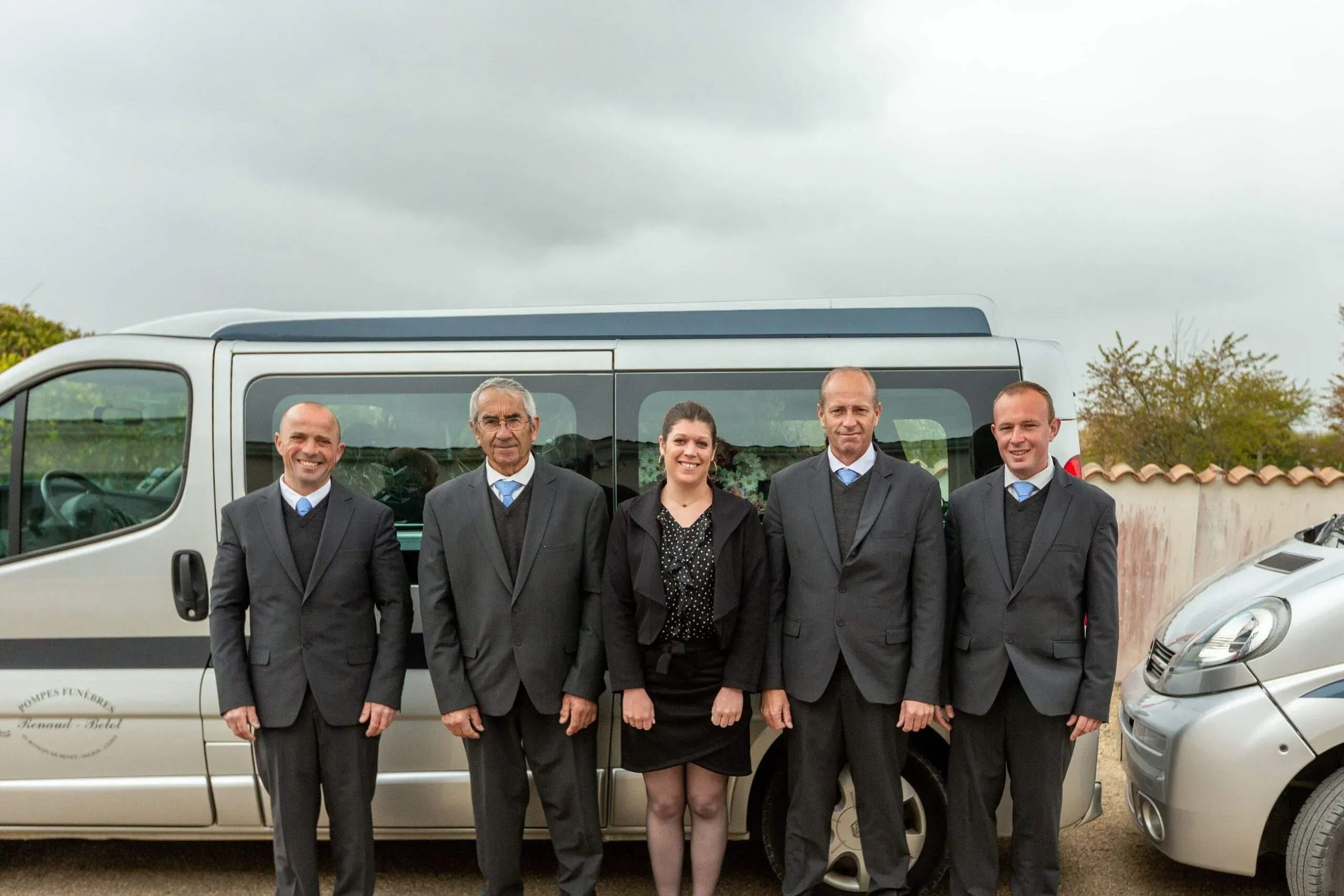 Portrait de l'équipe funéraire Renaud-Belot devant leurs véhicules de service.