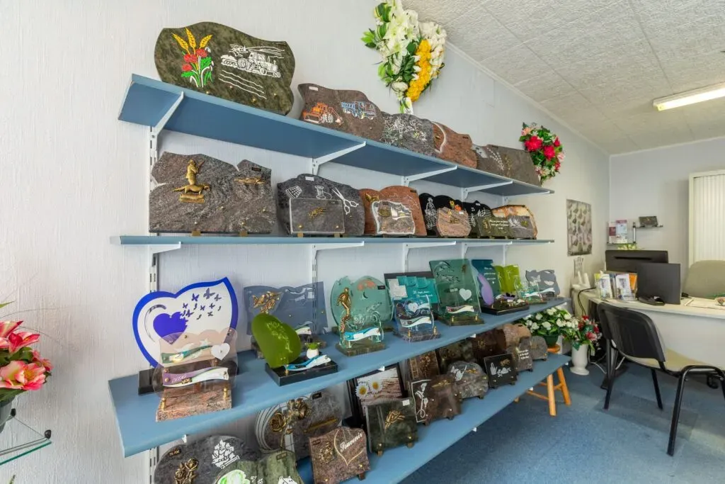 Plaques funéraires personnalisées exposées sur des étagères dans un magasin.
